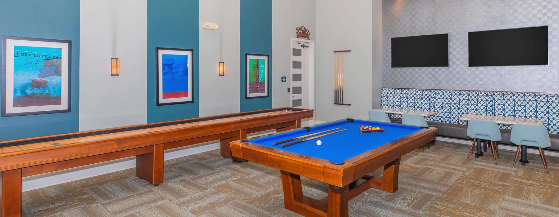 a room with a pool table and chairs